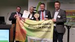 Eine Gruppe Menschen bei der Urkundenübergabe Bienenstrom Eine Gruppe Menschen bei der Urkundenübergabe Bienenstrom
