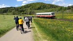 Eine Gruppe Radfahrer fährt an einer Bahnstrecke entlang Eine Gruppe Radfahrer fährt an einer Bahnstrecke entlang