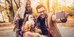 Eine Familie macht mit ihrem Kind im Rollstuhl ein Selfie