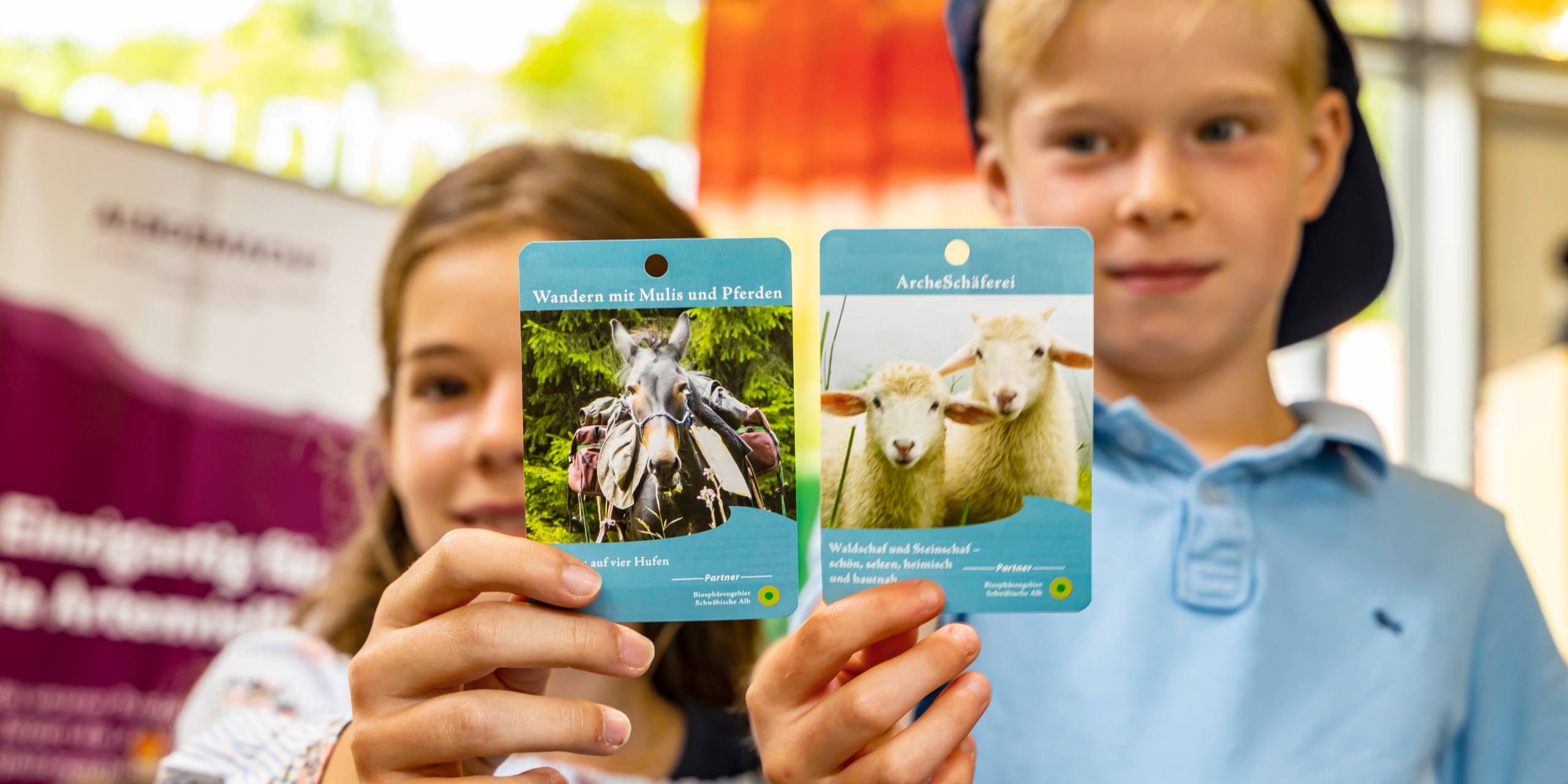 Kinder halten Kärtchen zu den Partnern des Biosphärengebiets in der Hand.